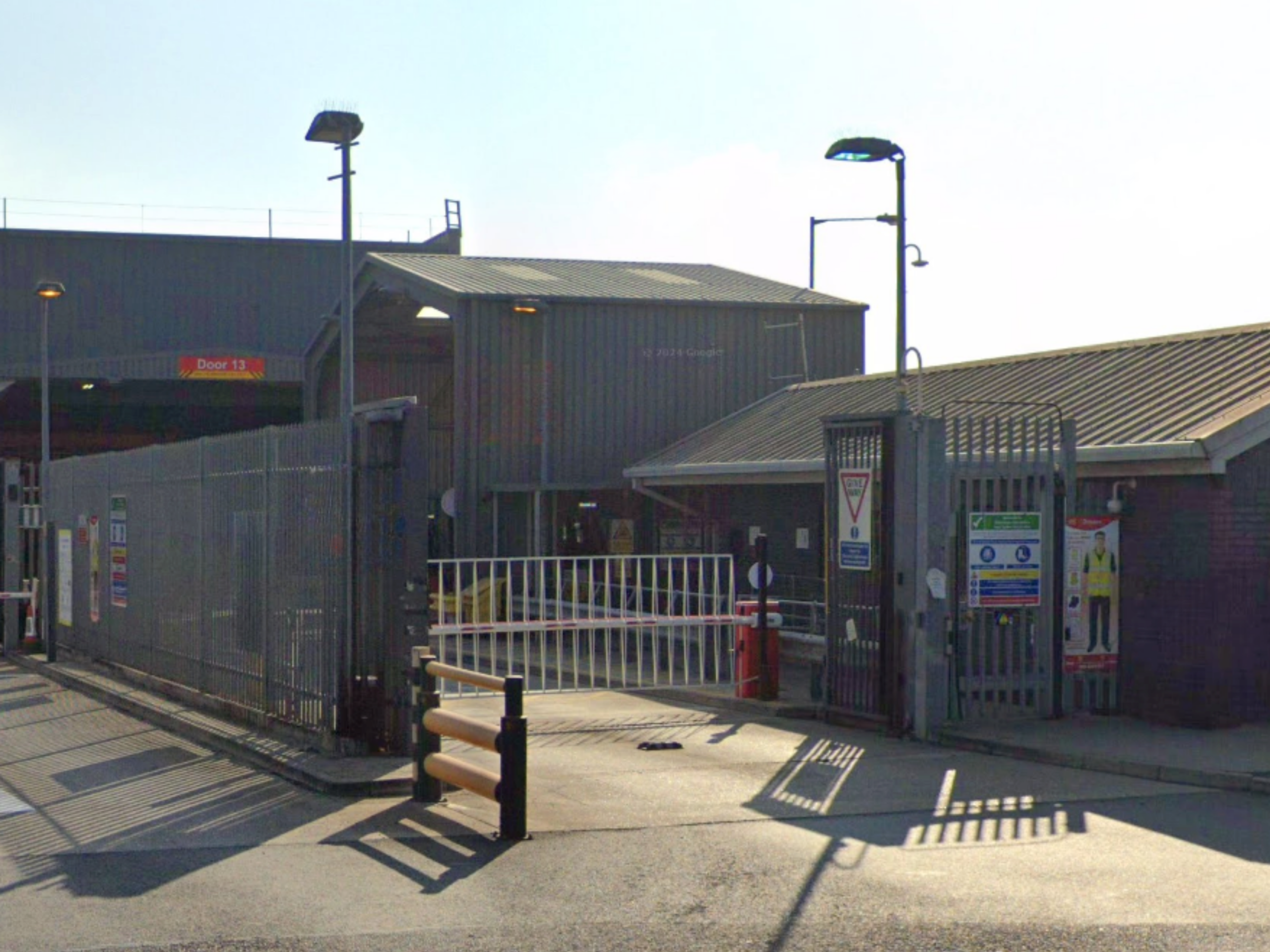 Automatic traffic barrier, bi-folding gate and perimeter security fencing at a secure distribution centre, installed by Industrial Gates and Barrier Systems